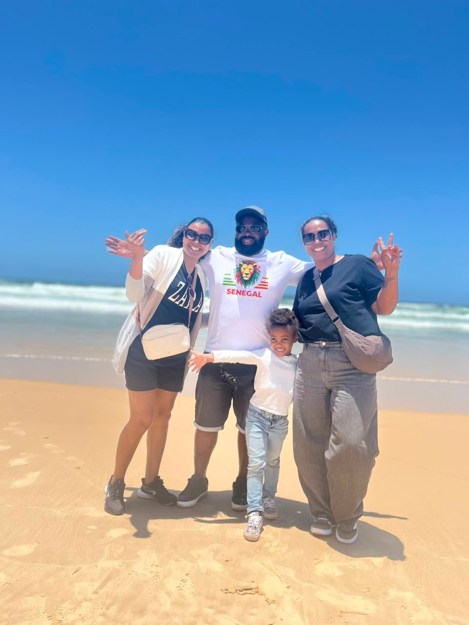 Famille souriante réunie sur la plage